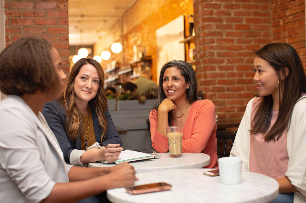 Four women having a meeting in a cafe.